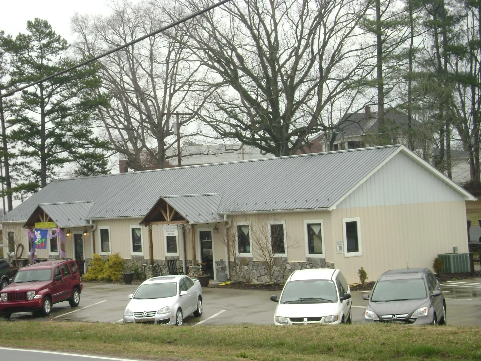 Gray metal roof with timber entry brackets on a small commercial building in Kensington